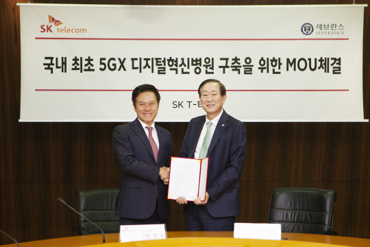 박정호 SK텔레콤 대표(왼쪽)와 윤도흠 연세의료원장이 26일 서울 을지로 SK텔레콤 사옥에서 '5G 디지털혁신병원' 구축 협약을 맺은 후 기념사진을 찍고 있다.  SKT 제공